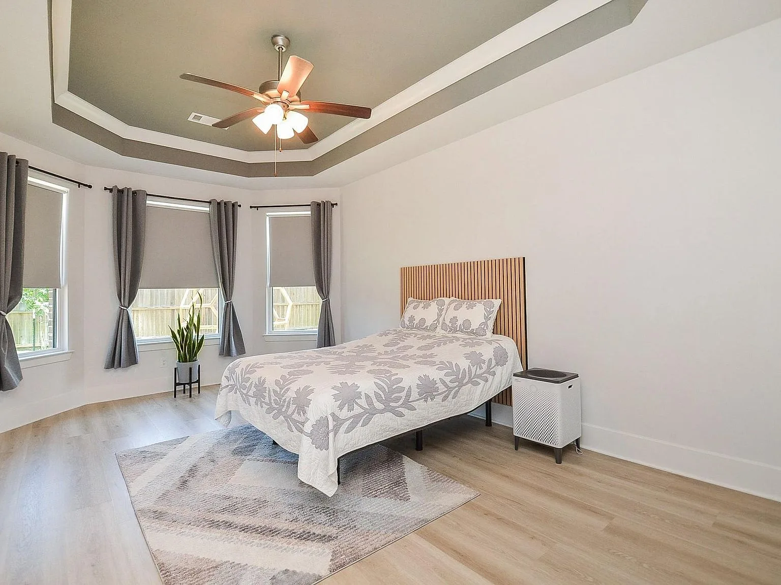 Primary bedroom with tray ceiling and zen-inspired styling