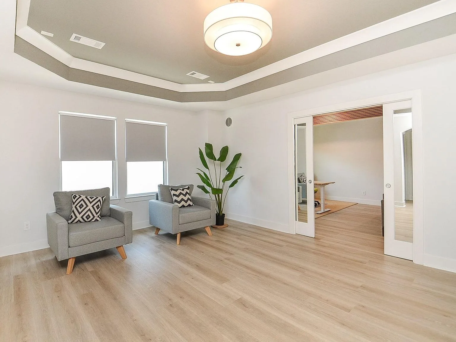 Bright lounge area with tray ceiling and sliding glass doors