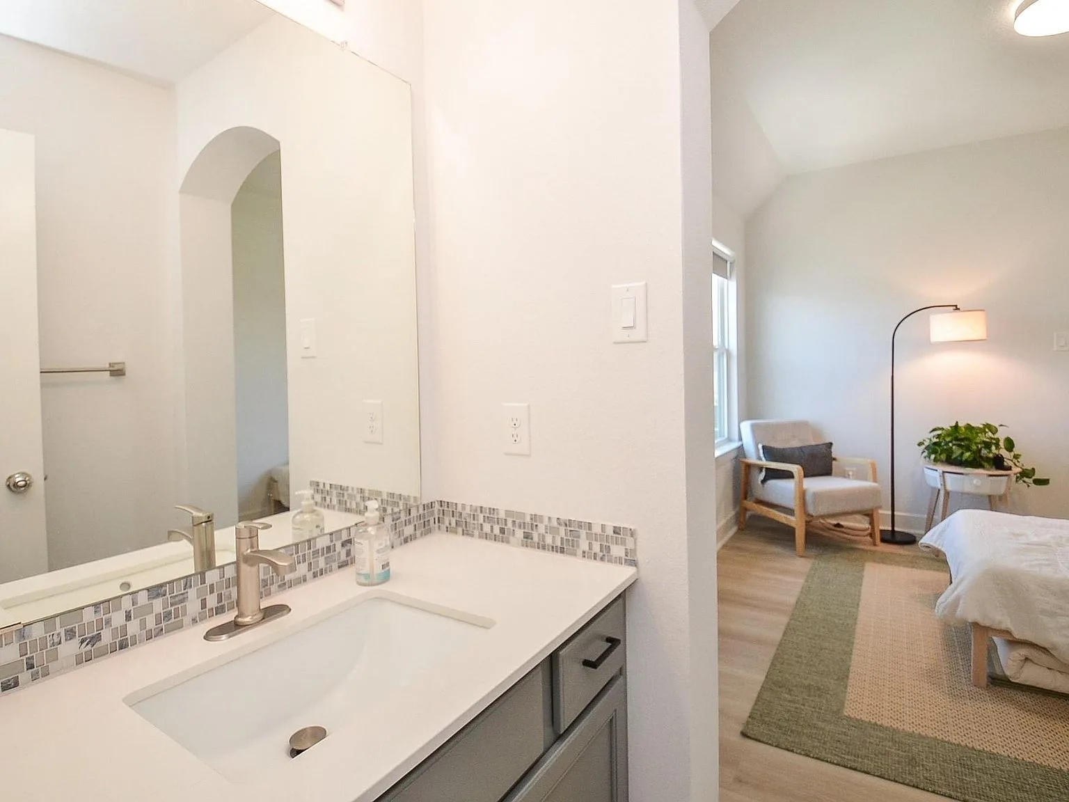 Bath vanity with quartz countertop beside a secondary bedroom