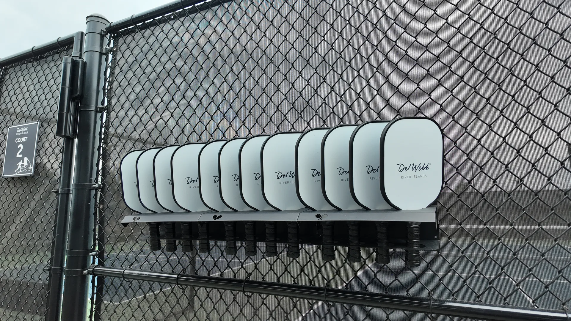 Pickleball paddles resting in a branded rack at the courts at Del Webb at River Islands in Lathrop, California