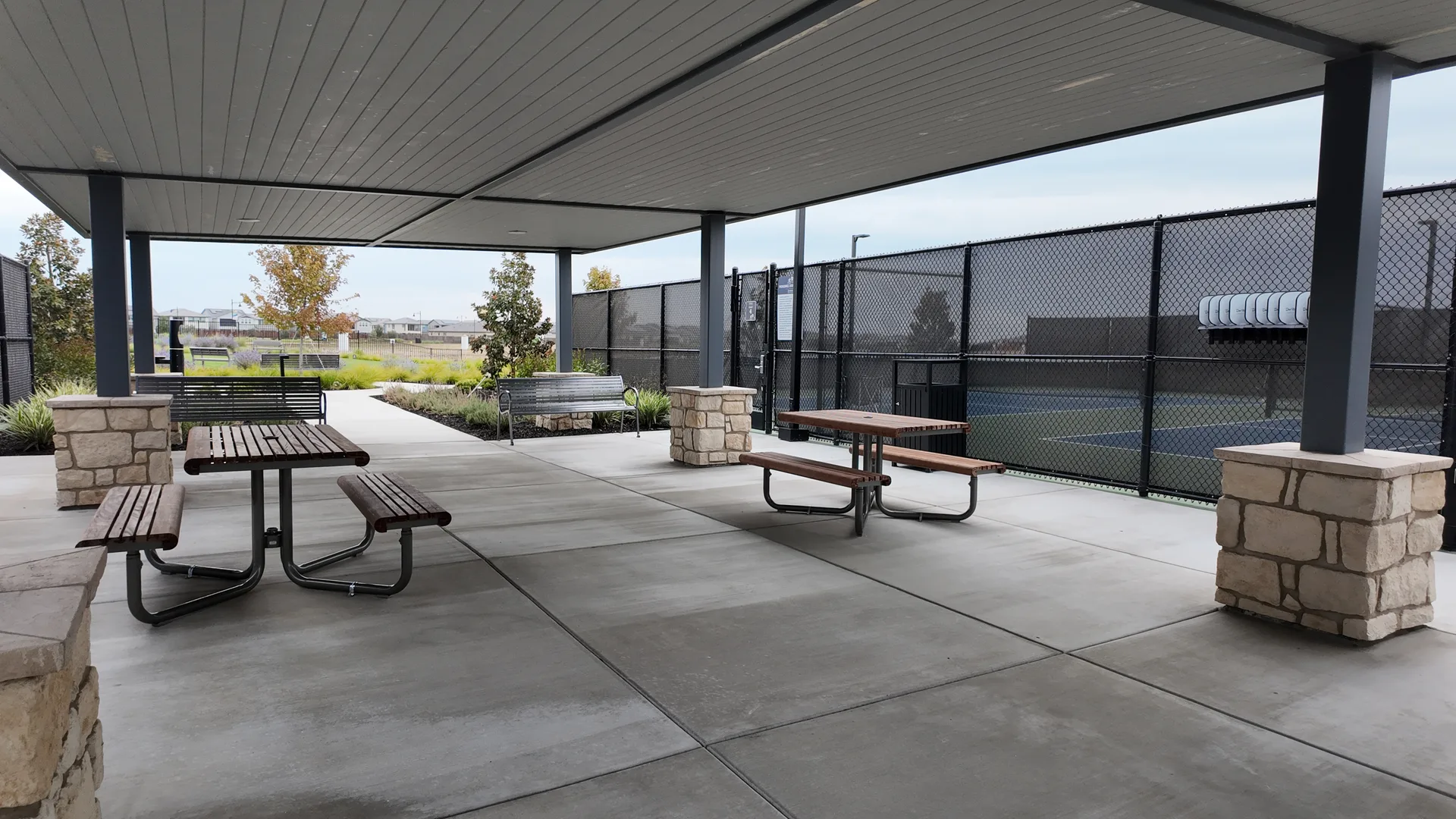 Outdoor recreation pavilion with picnic tables and seating beside the pickleball courts at Del Webb at River Islands in Lathrop, California