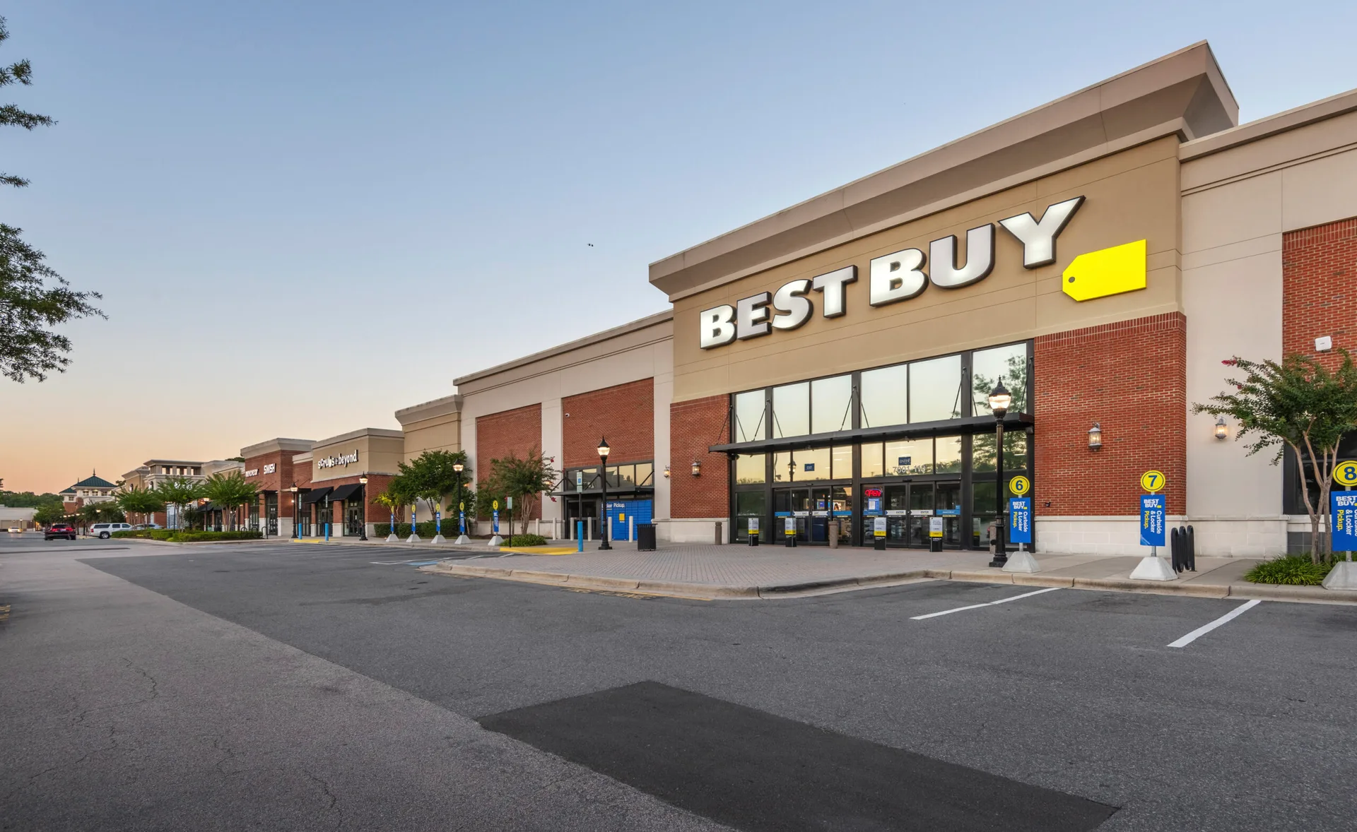 The Renaissance Center retail complex along Renaissance Parkway in South Durham, a Best Buy-anchored shopping center glowing in warm dusk light