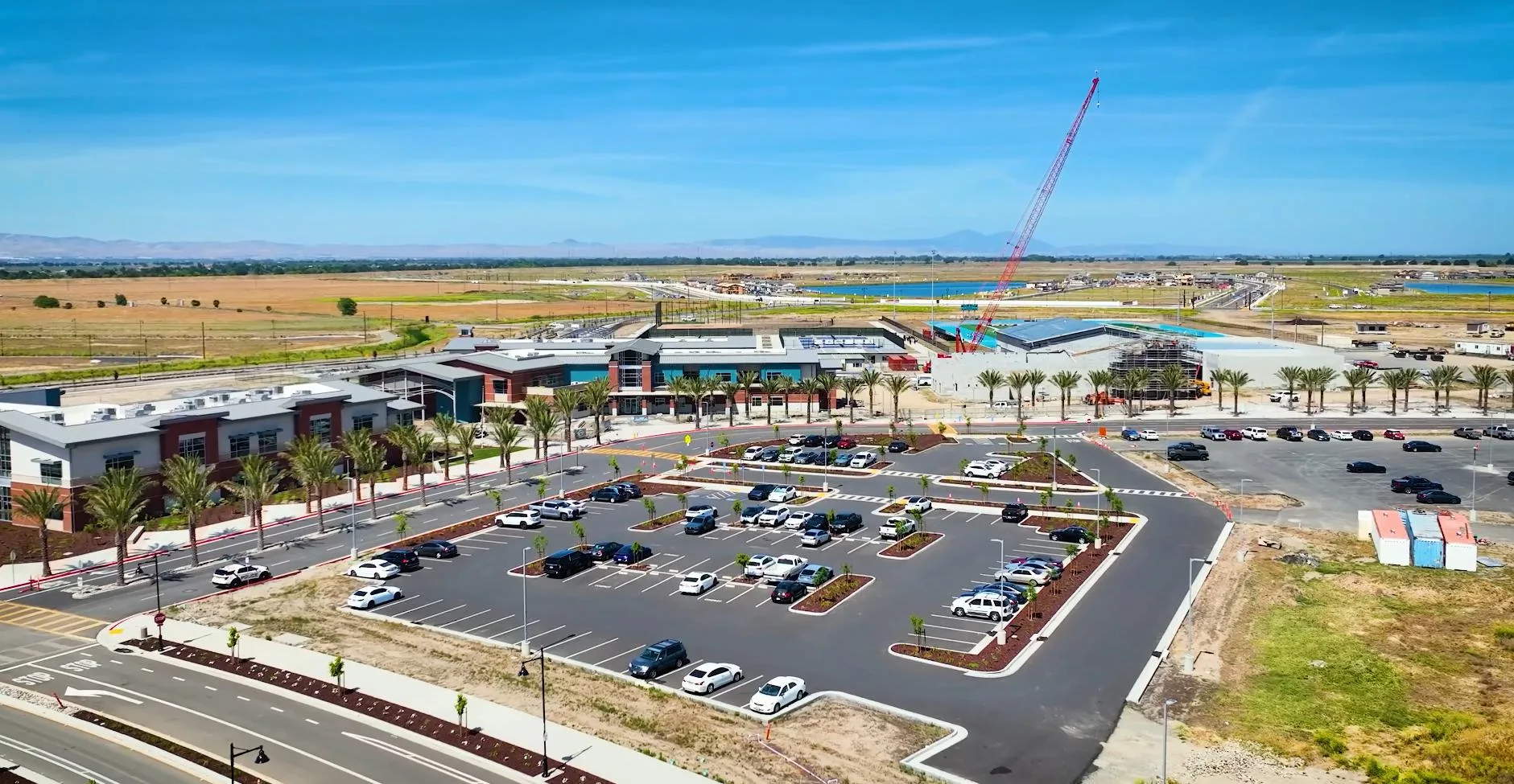 Aerial view of the River Islands Town Center area in Lathrop, California, under construction with a crane on site