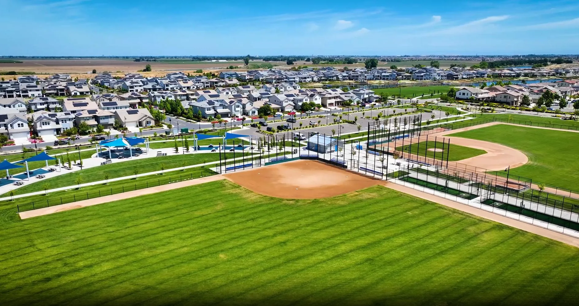 Aerial view of the two-field baseball and softball complex at River Islands in Lathrop, California, with dirt infields and tall backstop netting