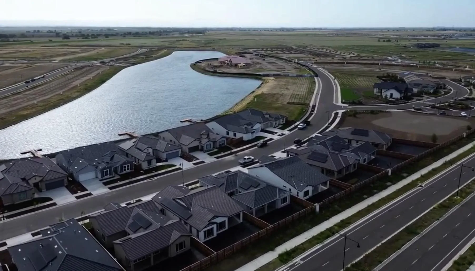 Aerial view of newer homes rising beside the water in a still-developing area of River Islands in Lathrop, California