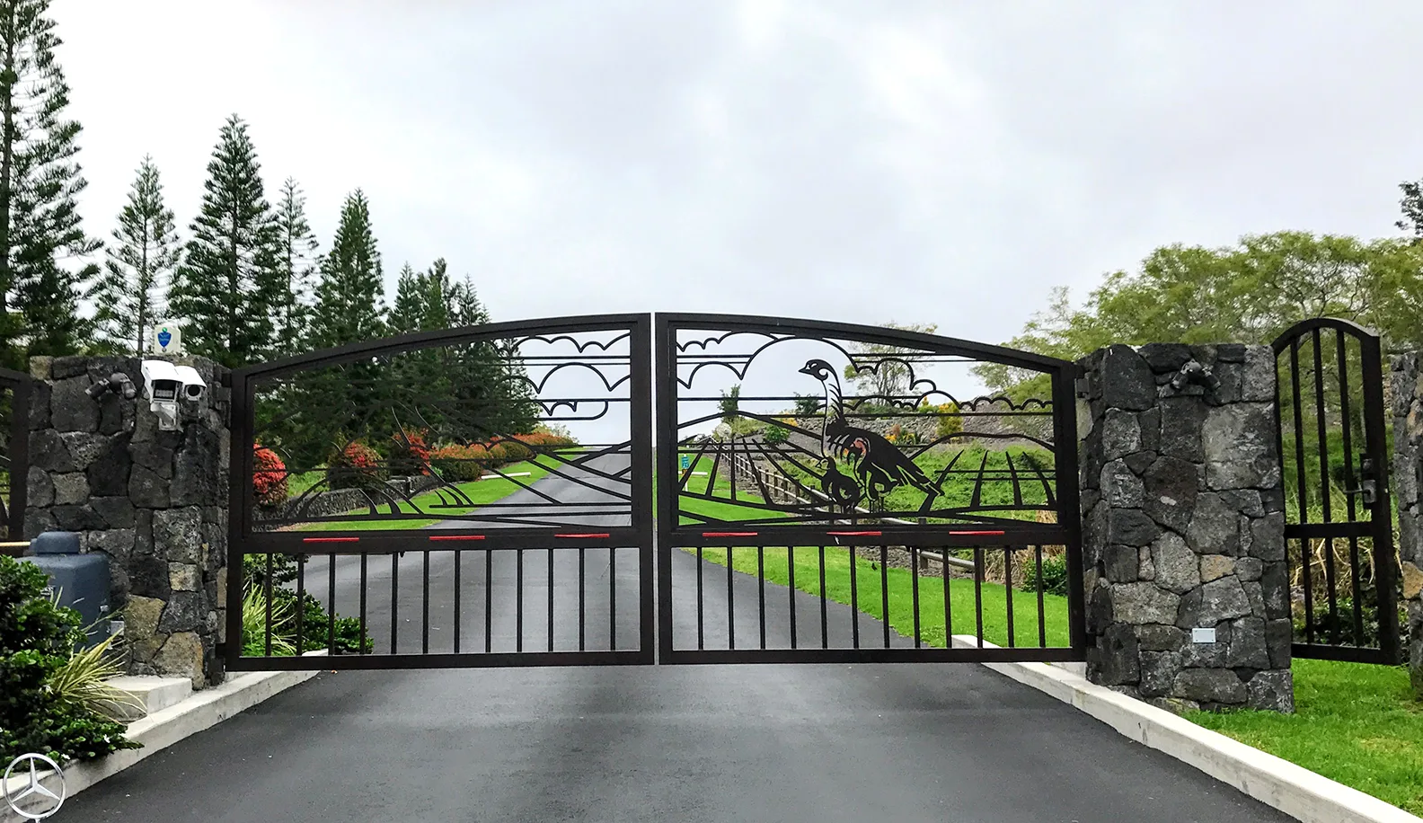The gated stone entrance to Puʻu Lani Ranch with a custom metal gate