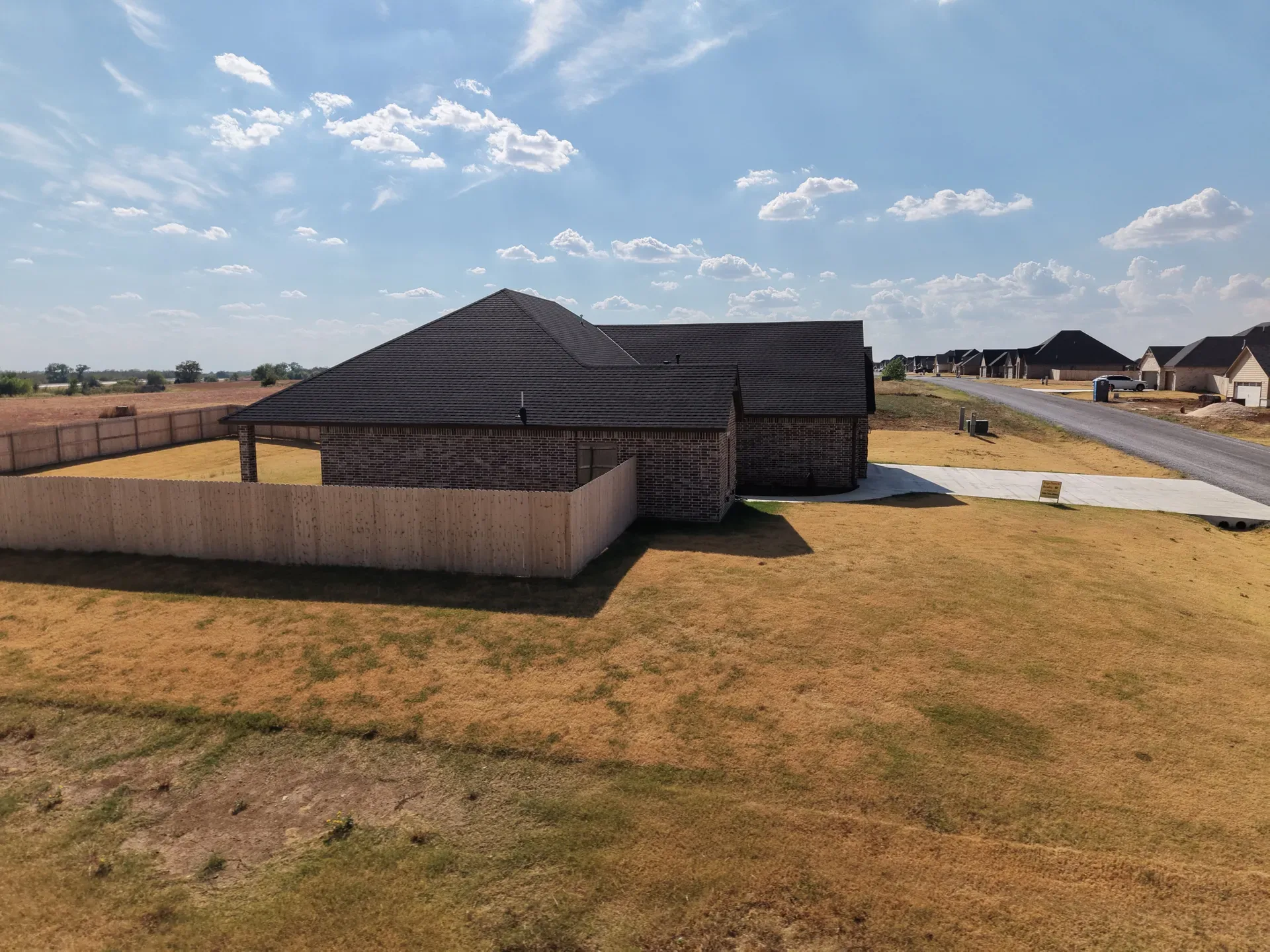 Aerial view of the rear and side of the property enclosed by wood privacy fencing