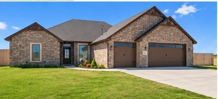 Straight-on front exterior of the single-story brick home under a clear blue sky