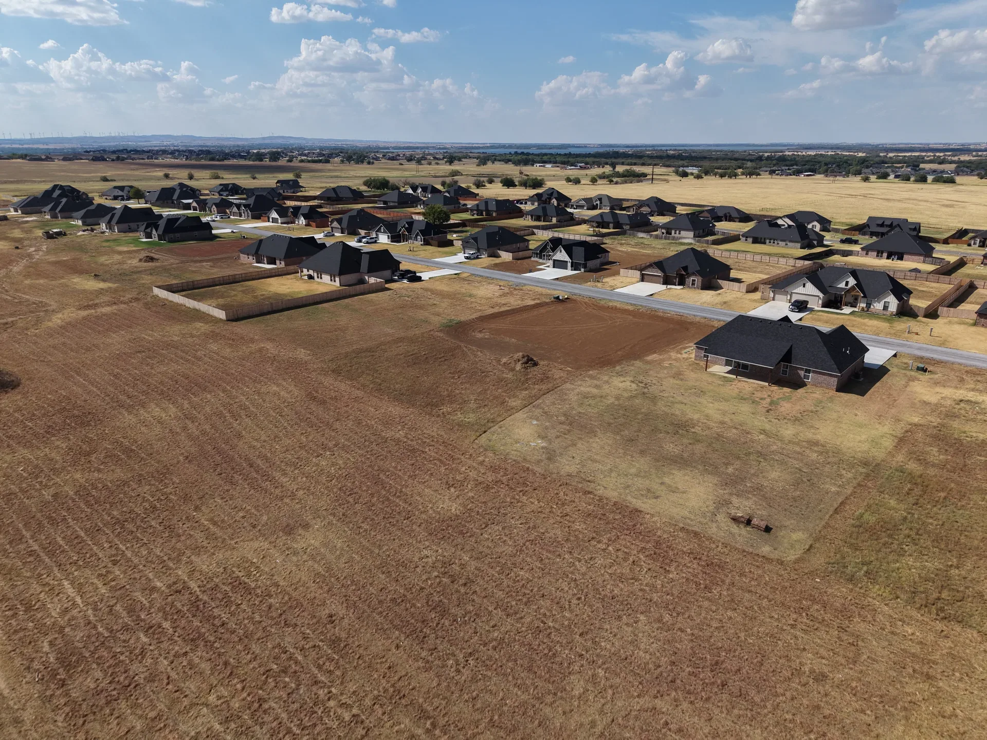 Aerial view of Legacy Creek Estates showing homes spread across large half-acre to one-acre lots with dark shingled roofs