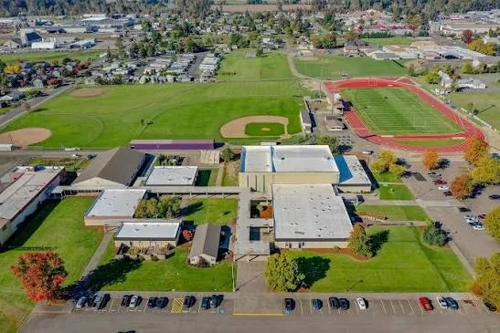 Aerial view of the Harrisburg school campus showing a track, athletic field, and ball diamond