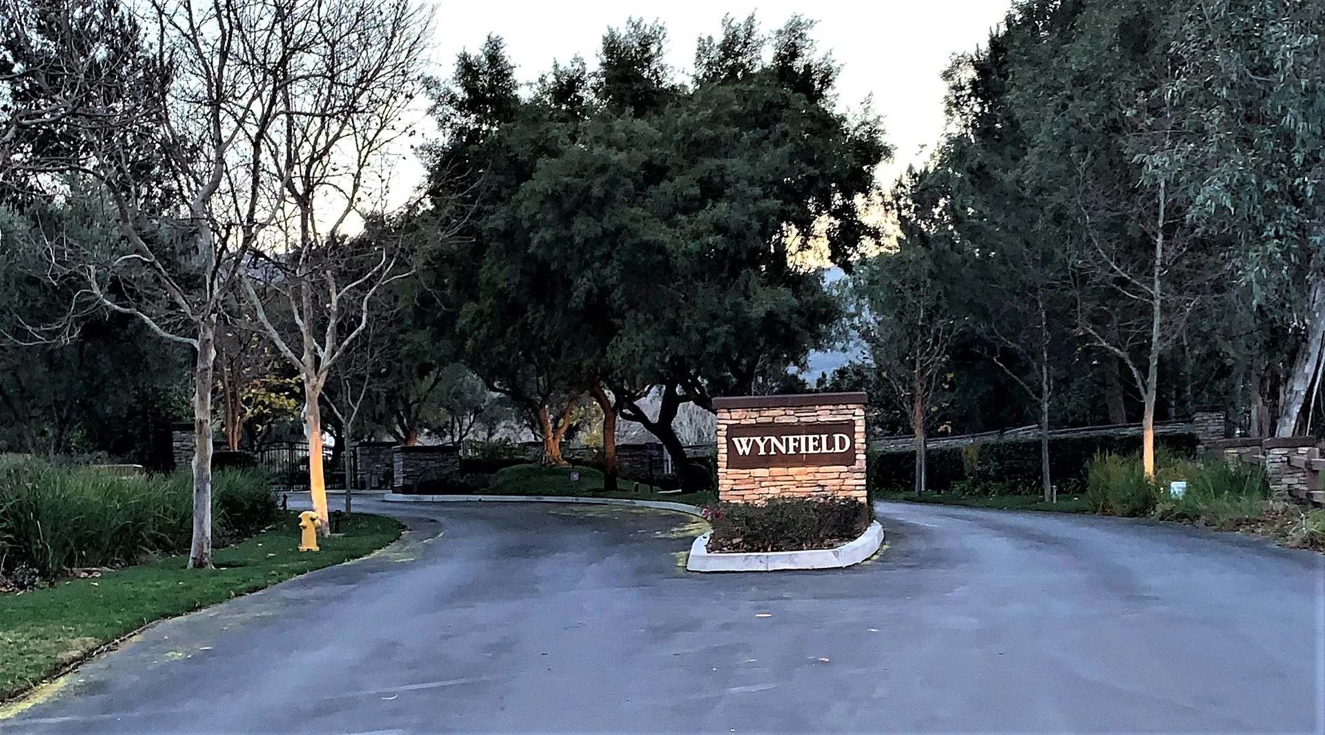 The gated stone entrance to Wynfield Estates at twilight in west Murrieta, California