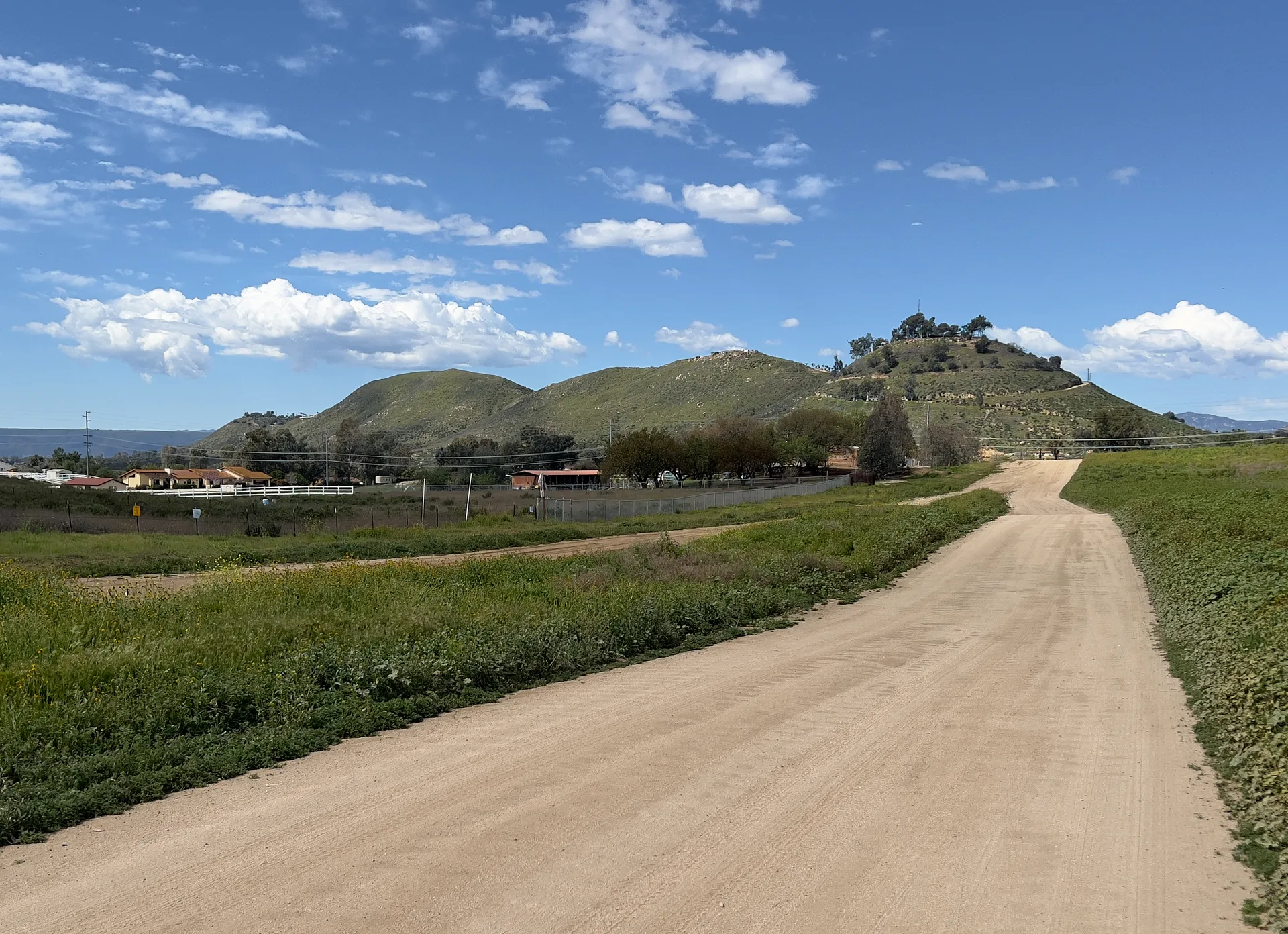 A quiet dirt road leading toward rolling hills in the Wildomar area of Southern California