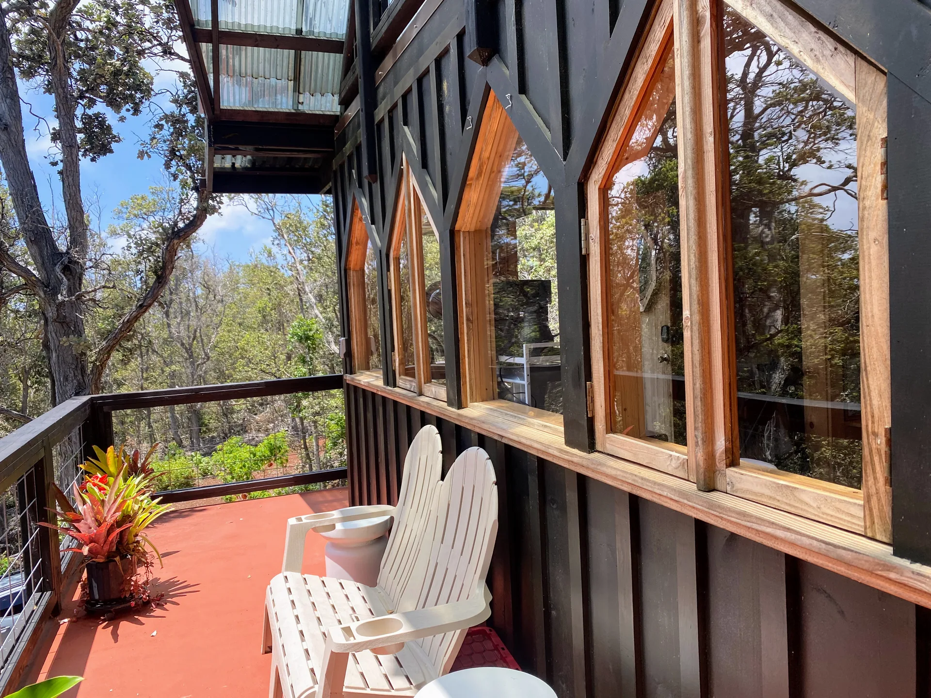 The custom wood-framed windows of the tiny treehouse in Kaʻū