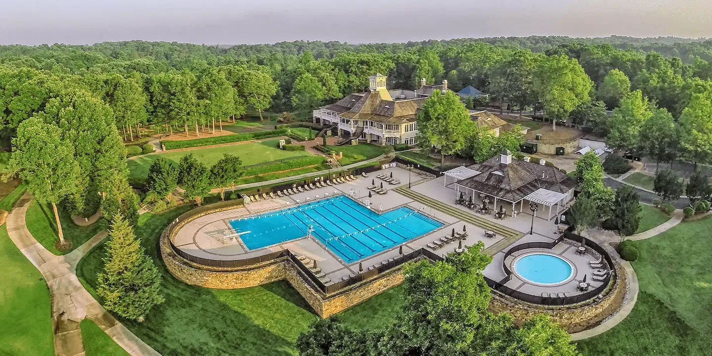 Aerial view of the Treyburn Country Club pool and clubhouse surrounded by forest in Durham NC