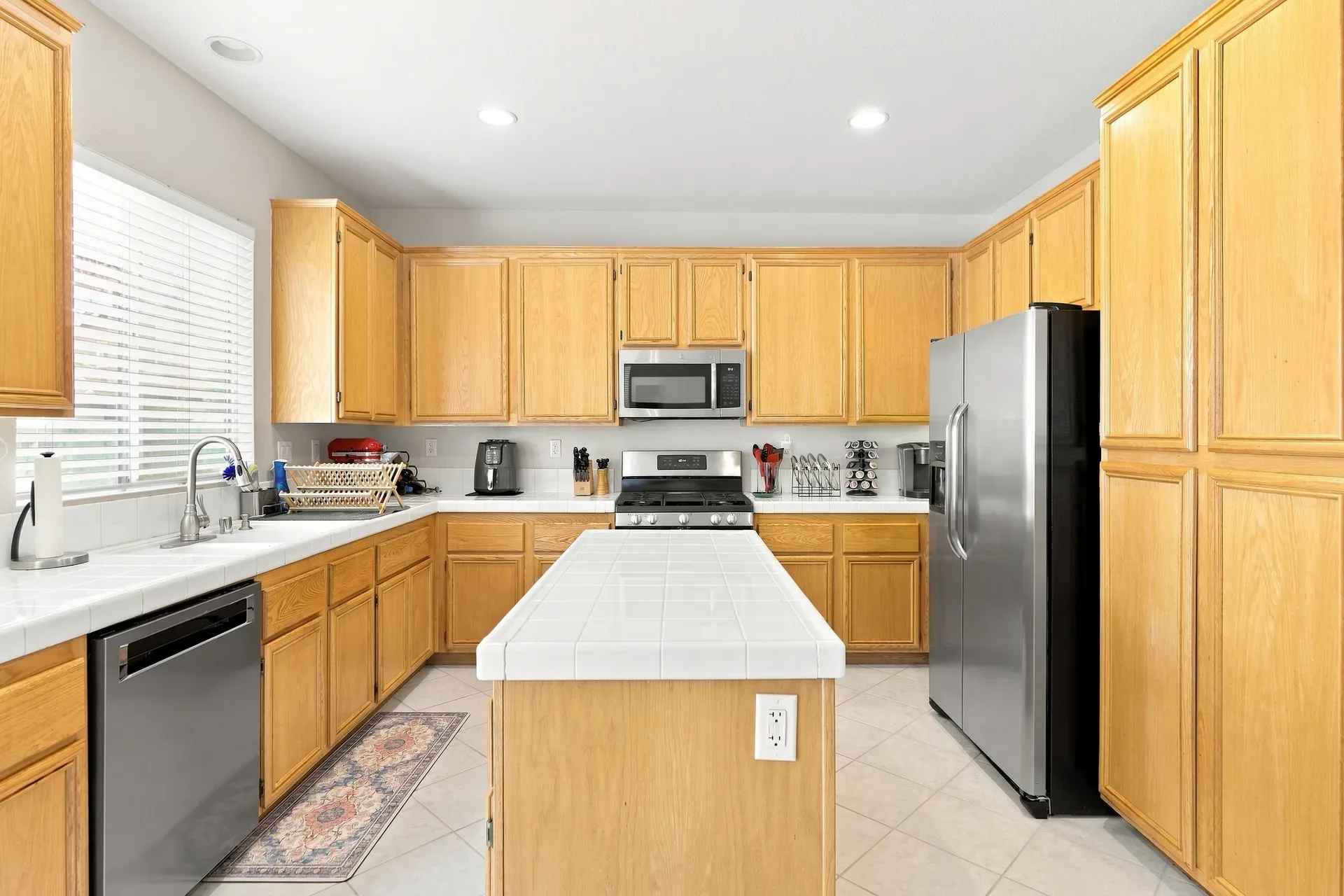 Wide kitchen view with island and stainless appliances