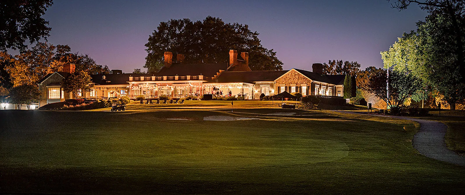 Twilight view of the illuminated Croasdaile Country Club clubhouse