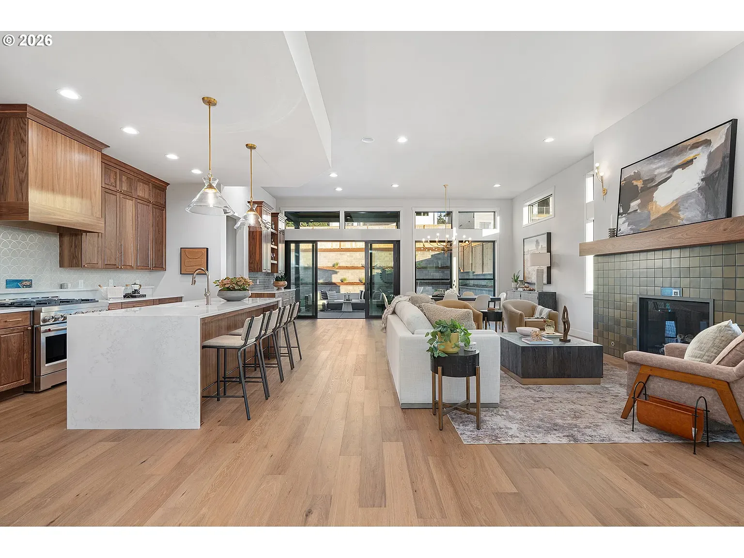 Kitchen & great room: Waterfall quartz island, custom cabinetry, olive tile fireplace