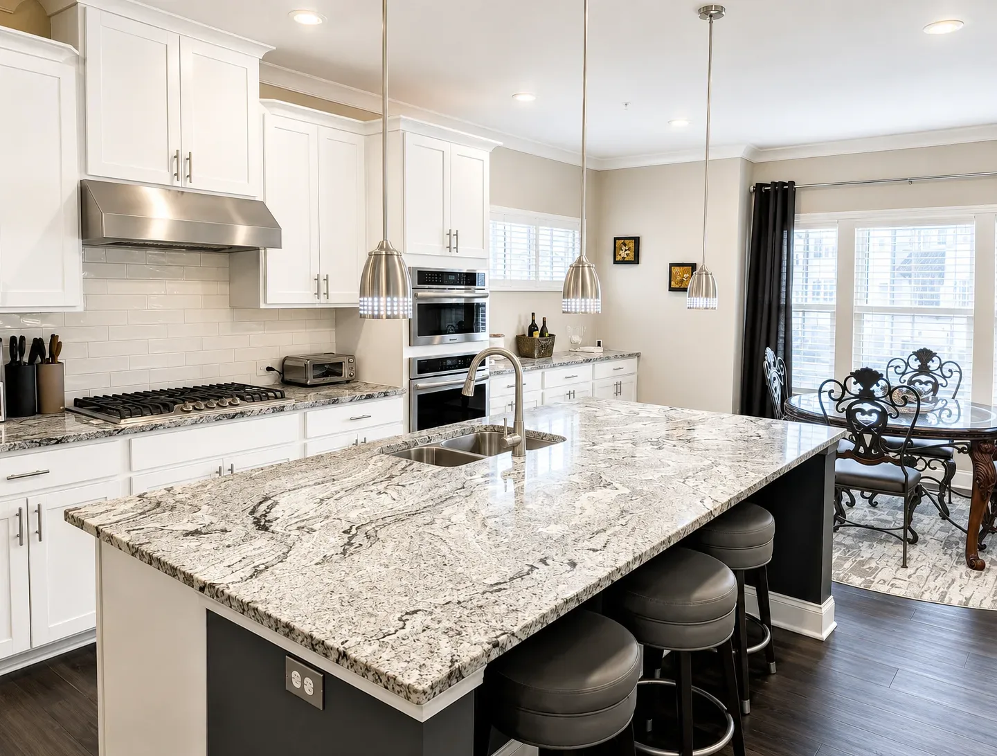 Modern white kitchen with granite countertops, subway tile backsplash and an island