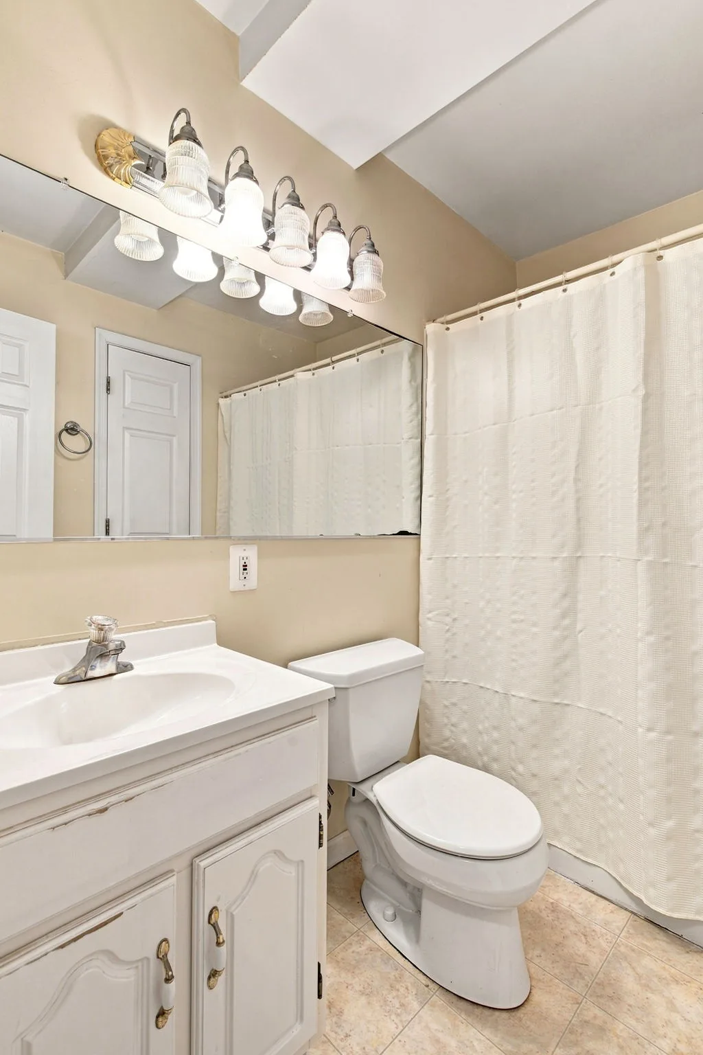 Bathroom with white vanity and large mirror
