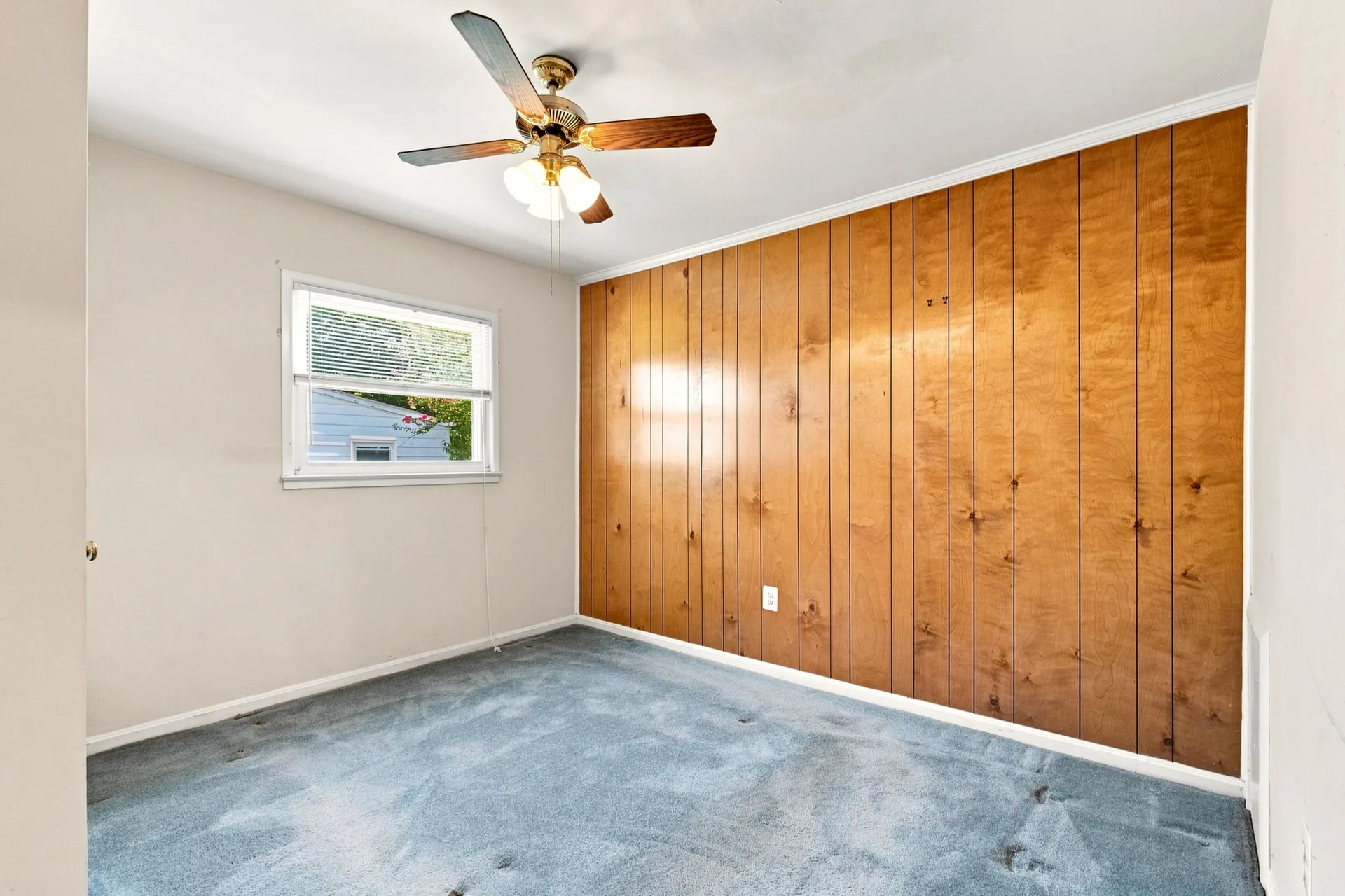 Bedroom with a wooden-paneled accent wall