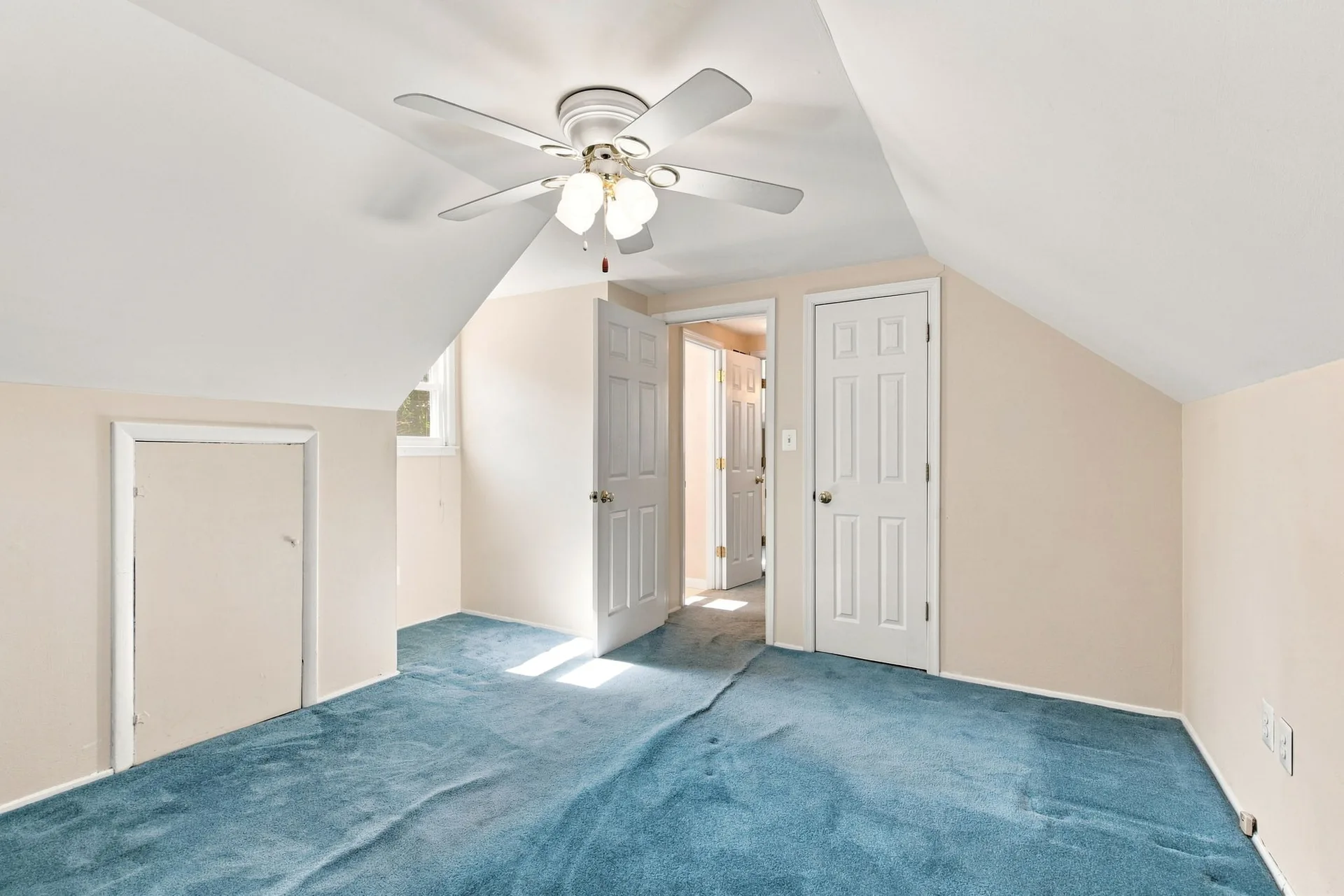 Upper-level bedroom with attic-style sloped walls and carpet