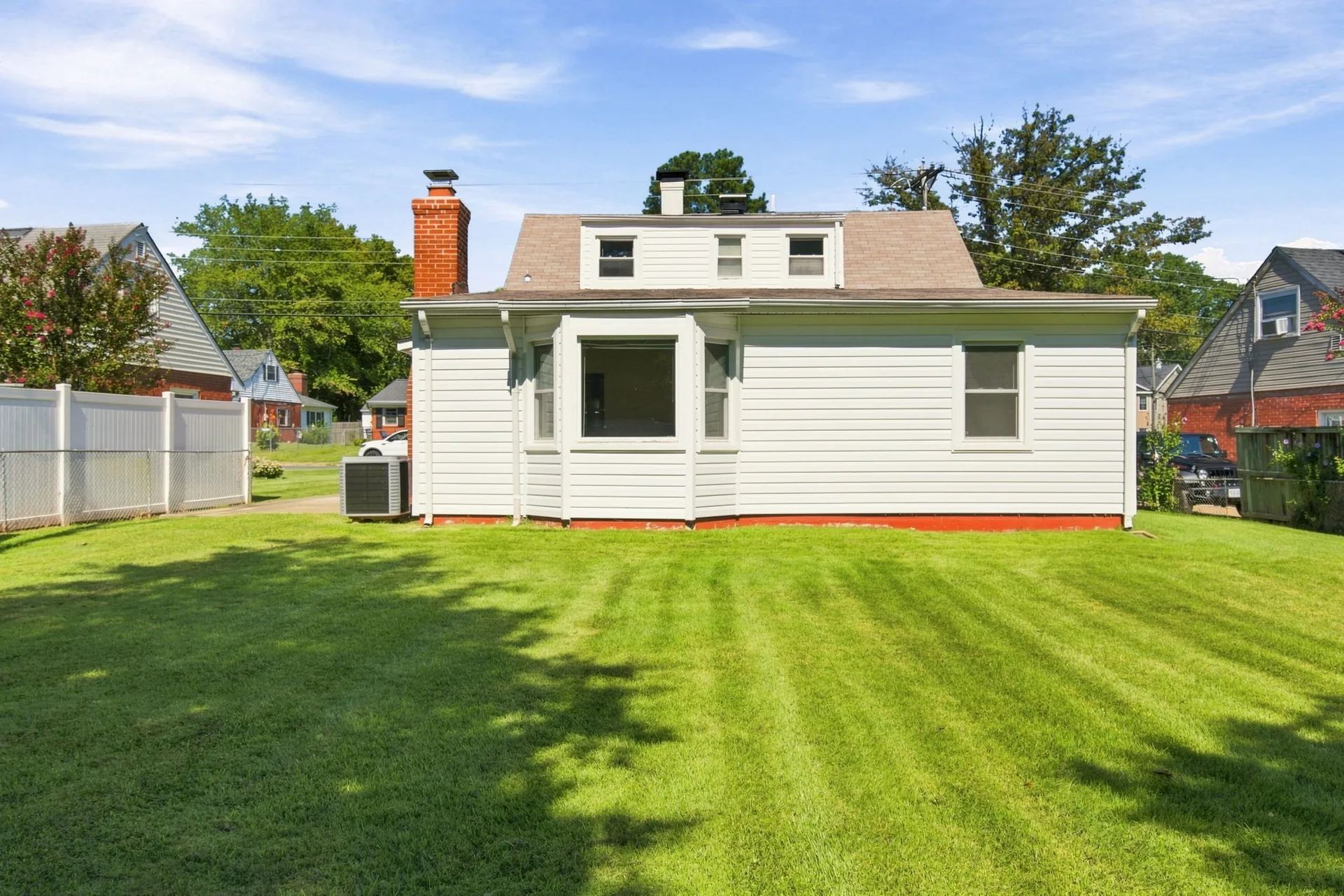 Rear exterior of the home looking across a manicured lawn