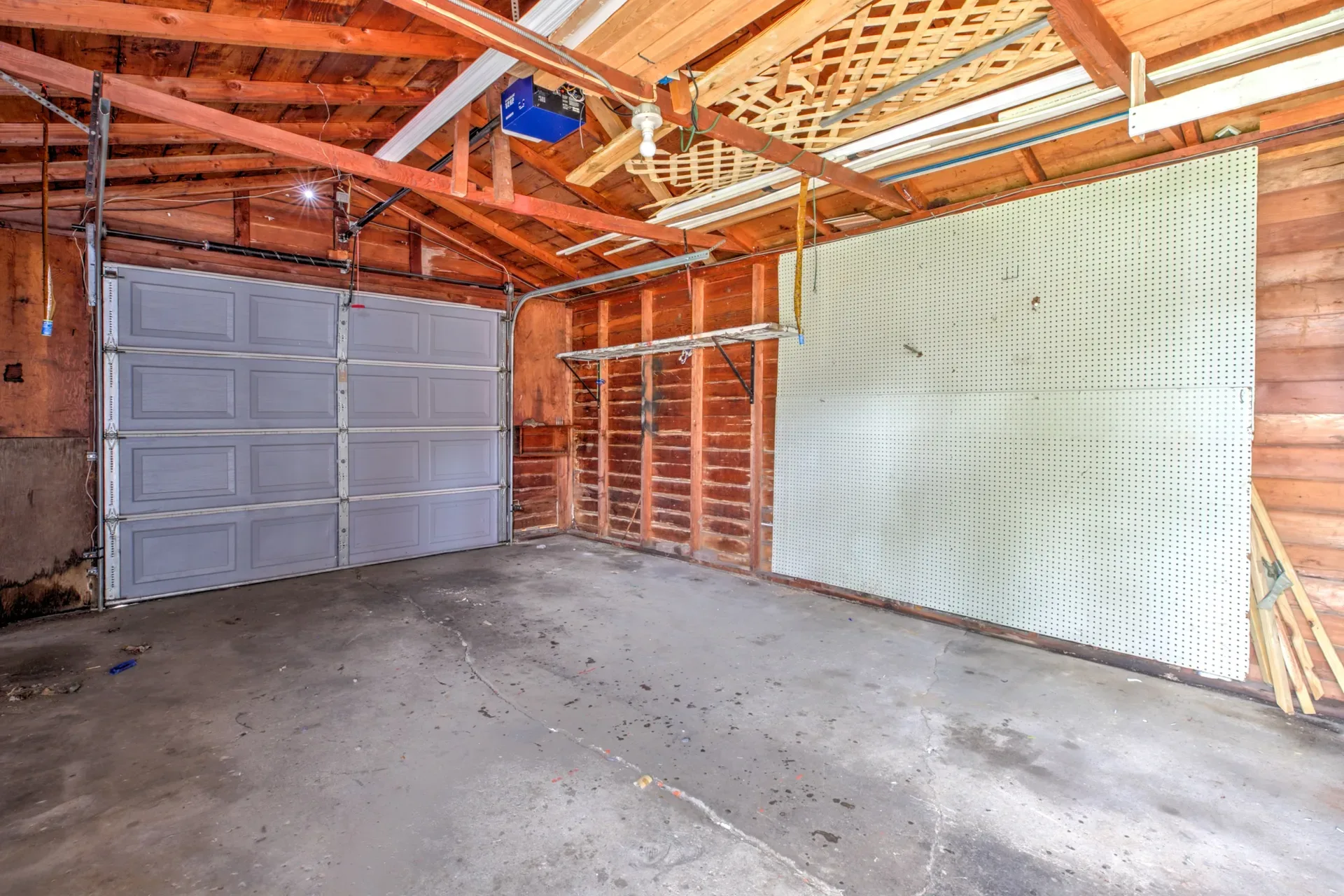 Detached garage interior with wood-paneled walls and exposed rafters at 902 E Maywood Ave