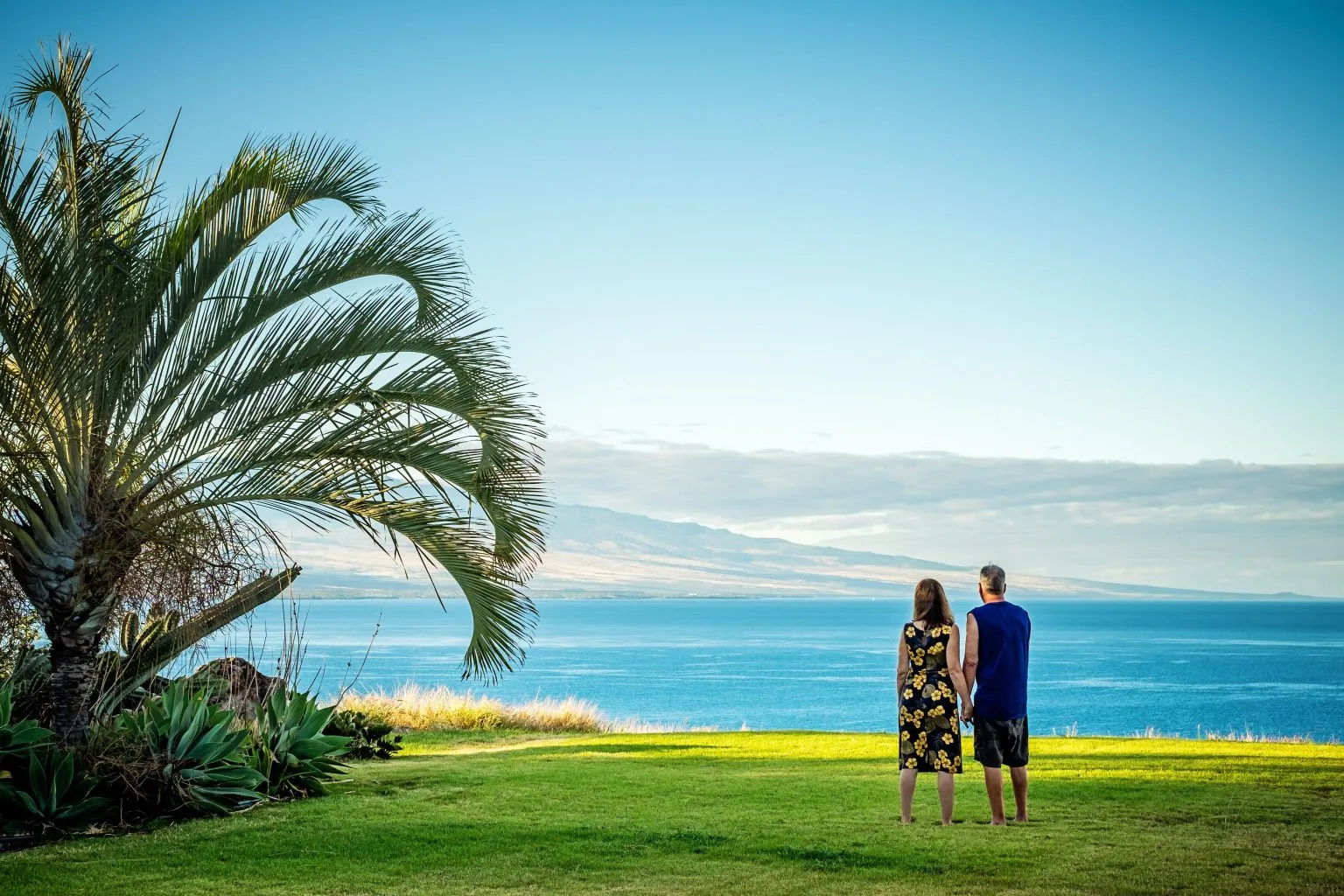 Two people walking on a lawn admiring the ocean view at Kohala by the Sea