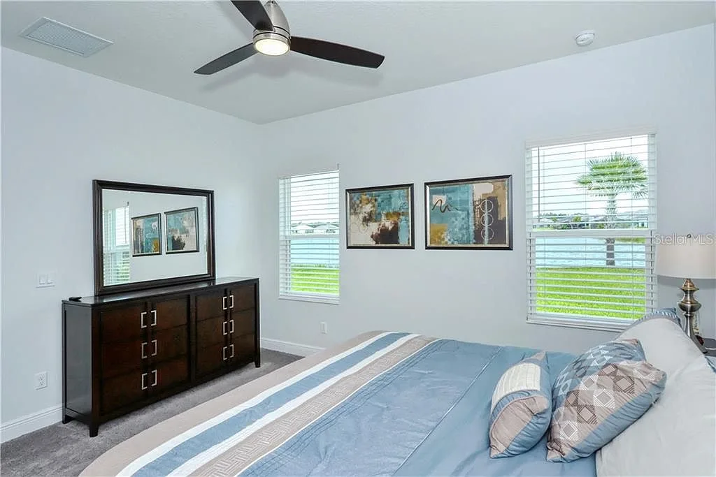 Primary bedroom with a view of palms and water