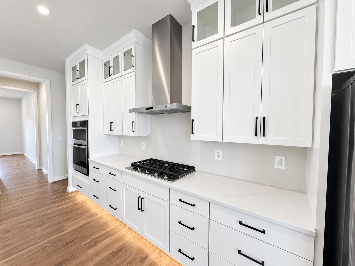 Bright neutral kitchen cabinetry with white shaker cabinets and quartz counters in the Torrey at Hampstead