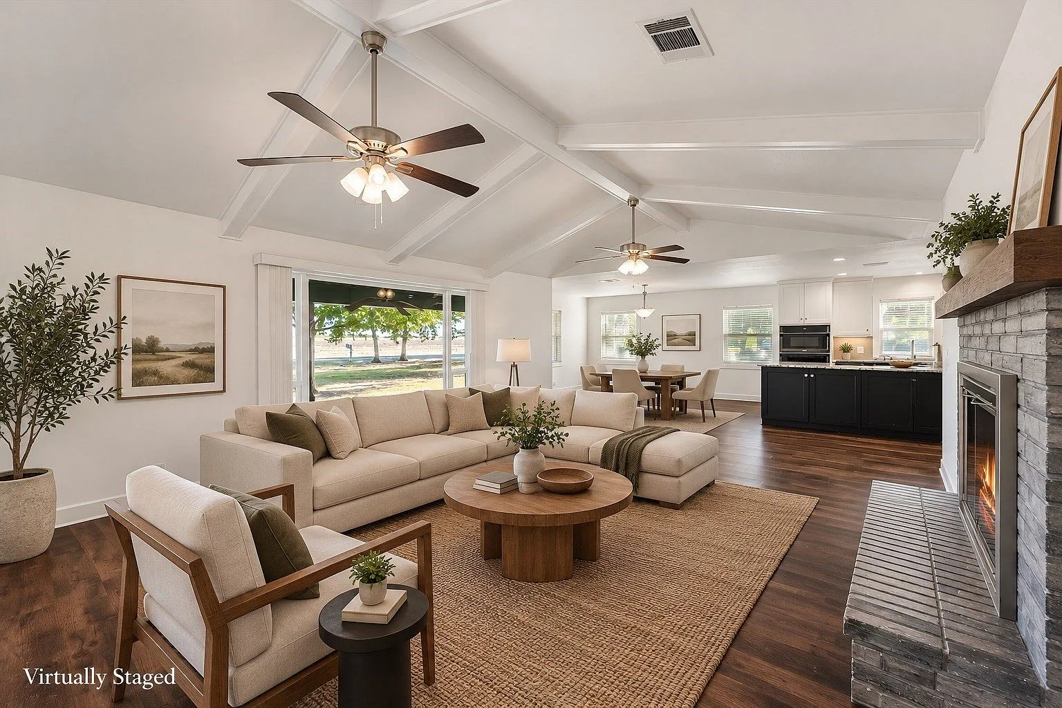 Open-concept living area with vaulted beamed ceiling and brick fireplace