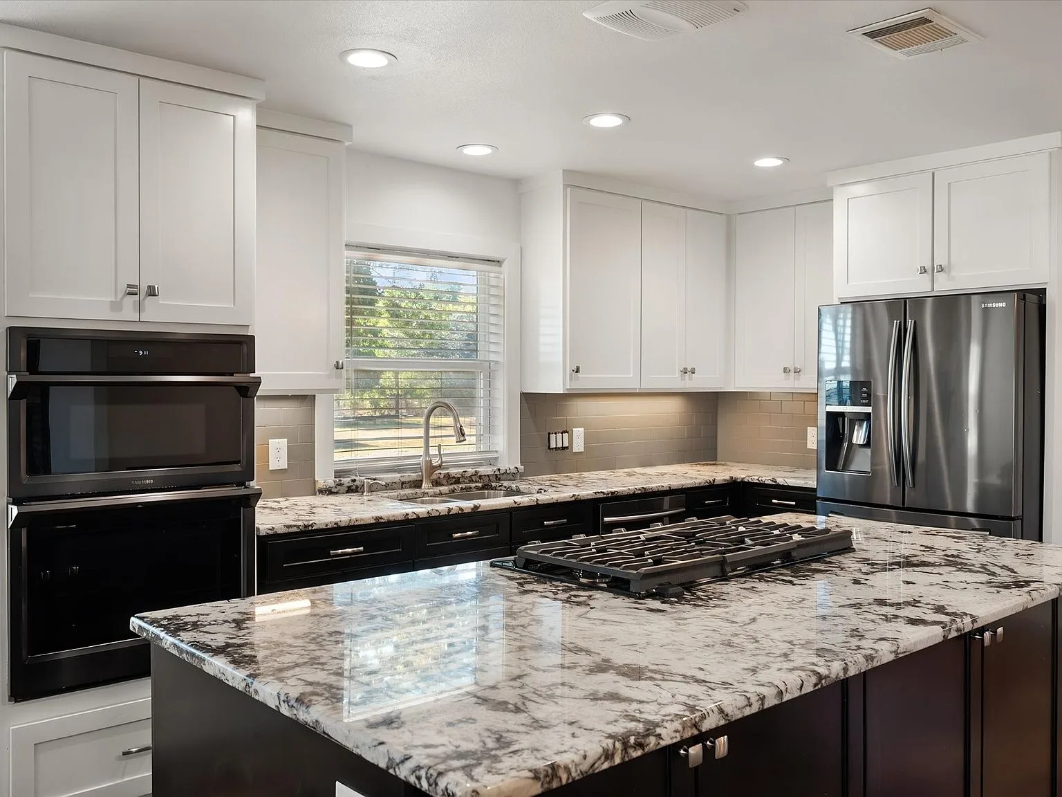 Renovated kitchen at 917 Goodwyn Rd with granite counters and double ovens