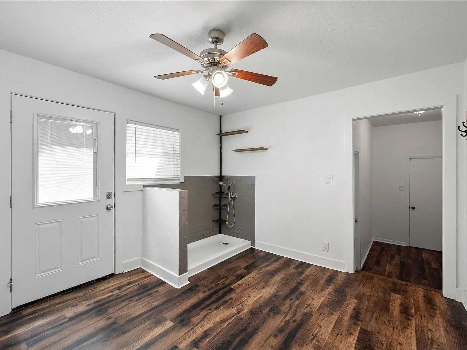Renovated mudroom with pet shower, floating shelves and dark plank flooring