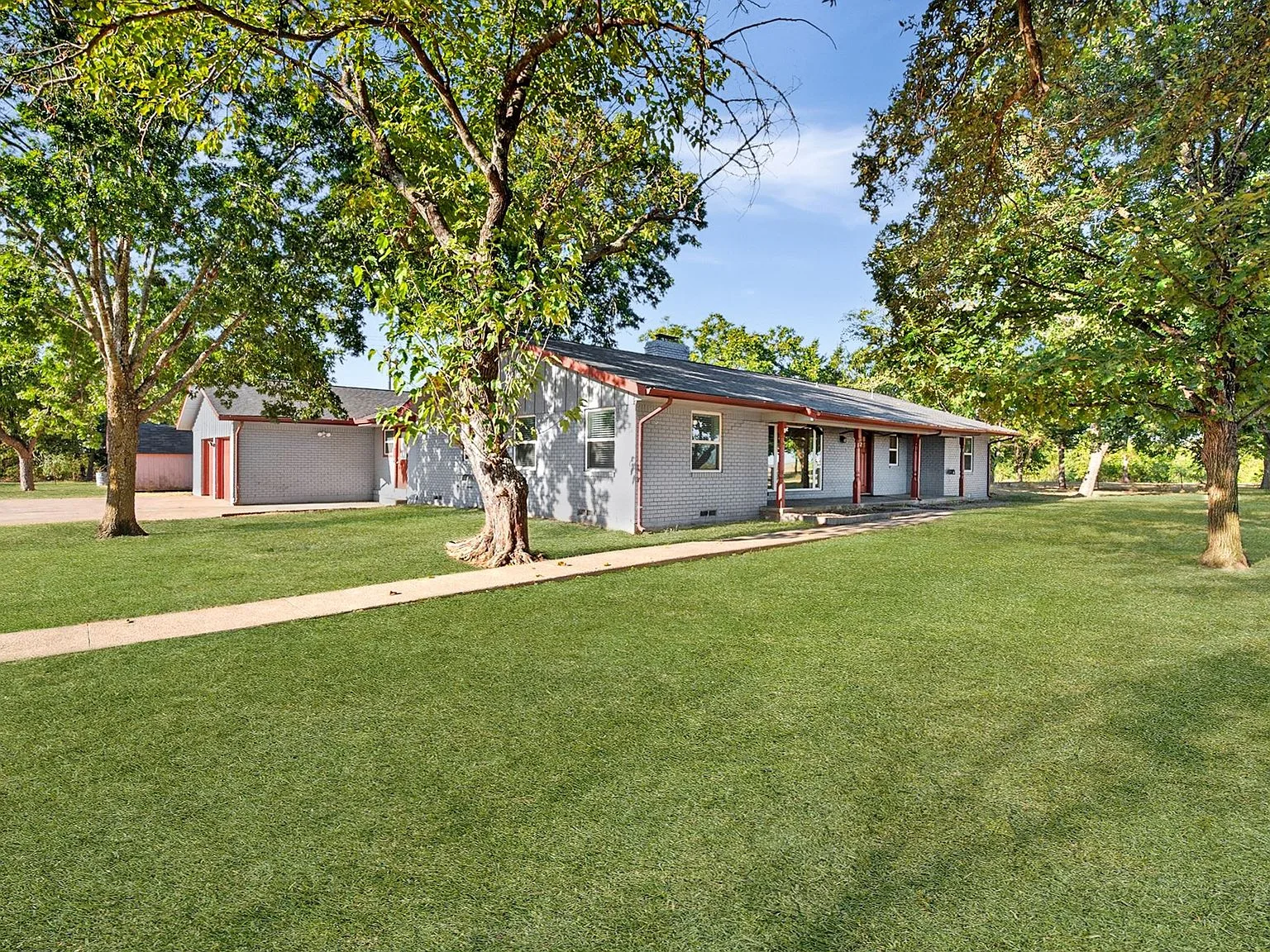 Angled view of the front and side of the ranch home with the detached garage
