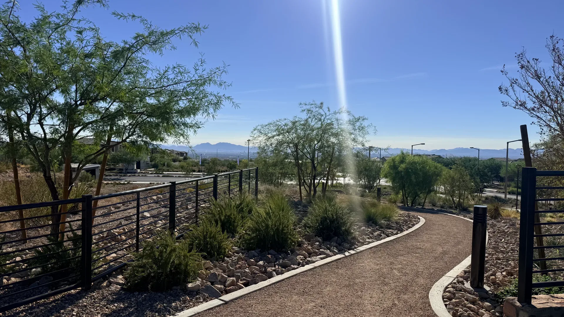 Summerlin walking path with a black railing and mountain views