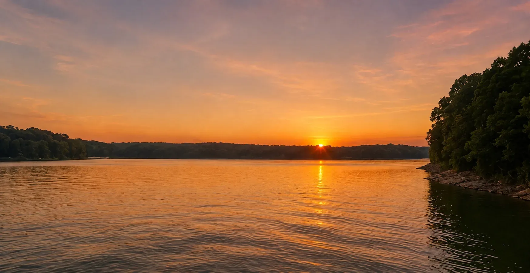 A lake at sunset with forested shorelines in south central Kentucky