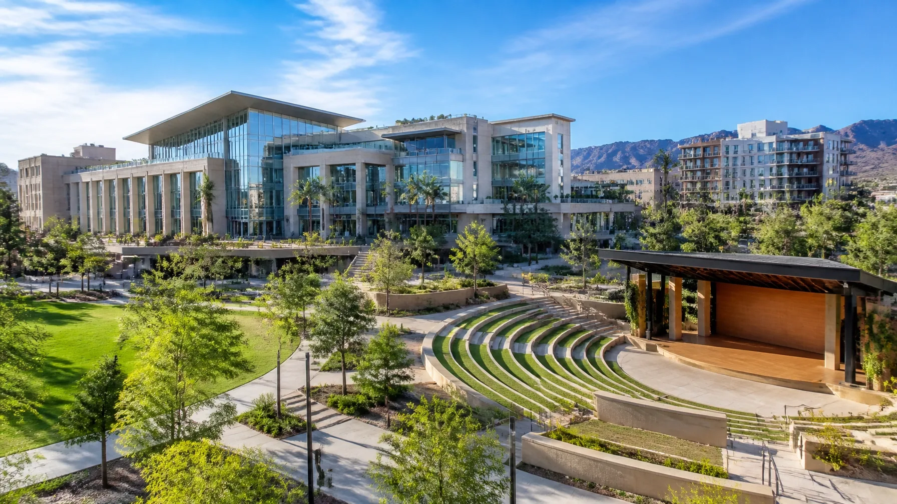 Stone amphitheater in a public park with modern buildings behind it