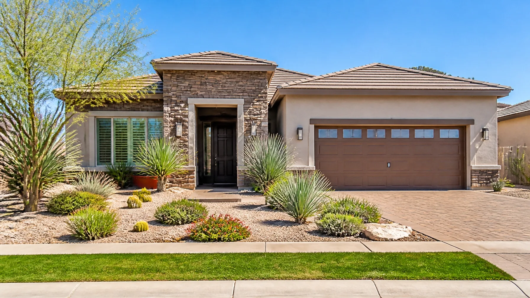 A single-story desert-style home with a tile roof and low-maintenance desert landscaping