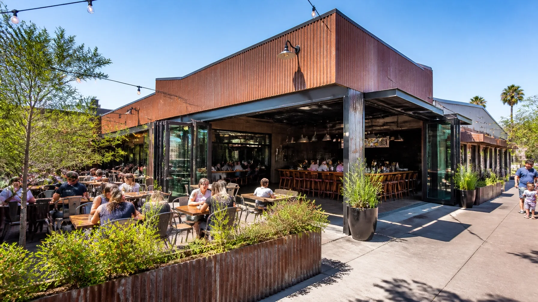 The exterior of a restaurant with an open dining area and patio