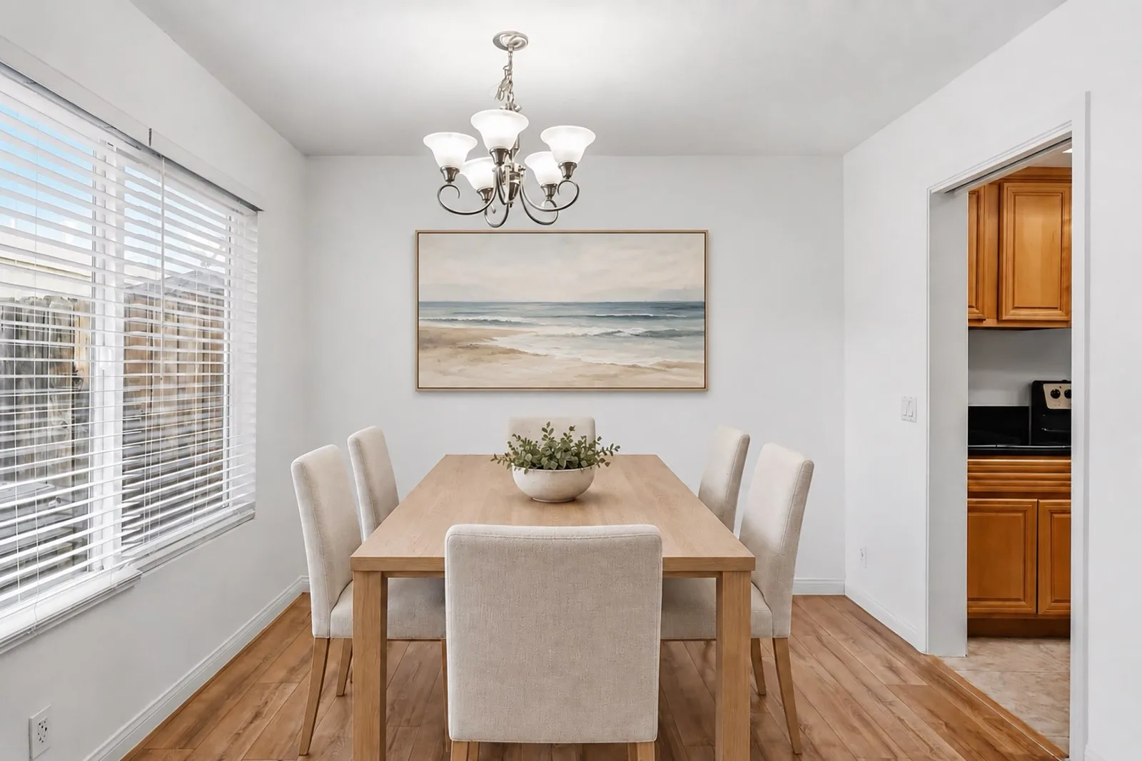 Virtually staged dining space at 8 Silverwood with a table and six chairs set beneath the staircase chandelier