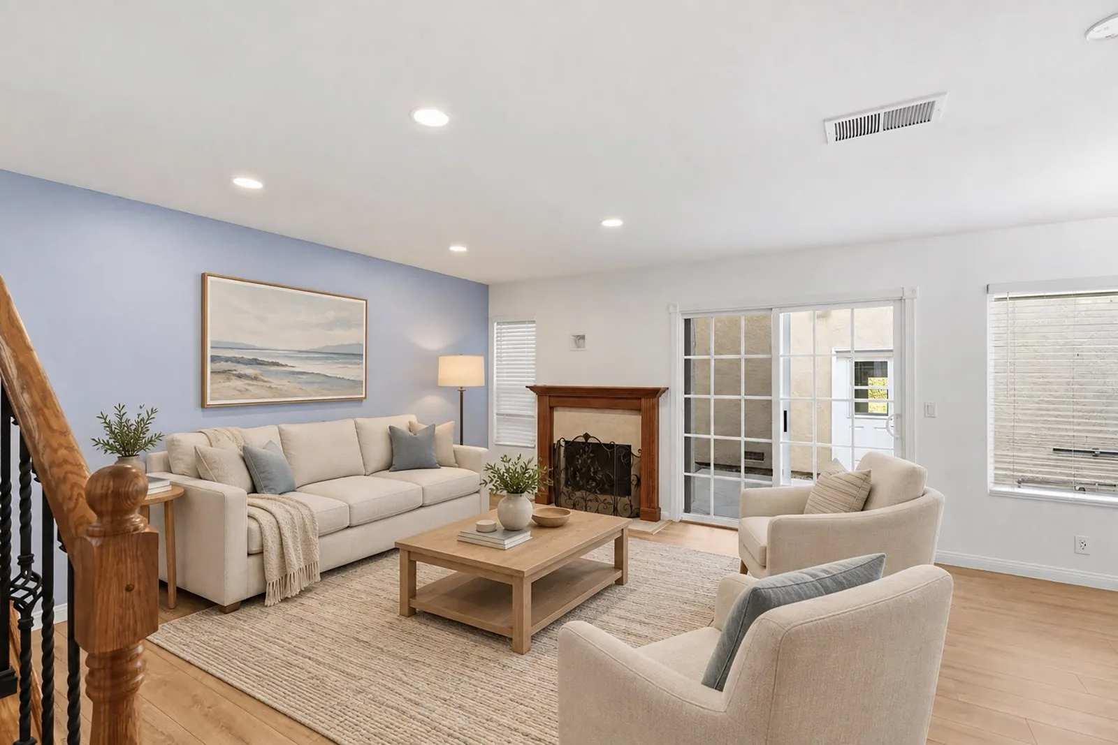 Virtually staged living room at 8 Silverwood with a cream sofa, armchairs, coffee table, and rug arranged around the wood-mantel fireplace