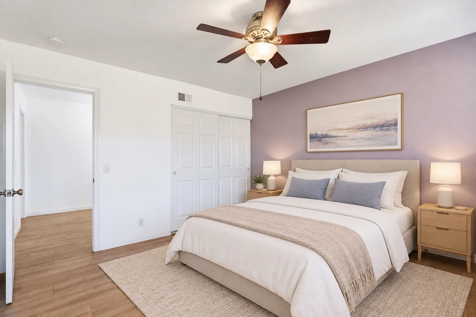 Virtually staged primary bedroom at 8 Silverwood with a bed, nightstands, and lamps against a soft accent wall