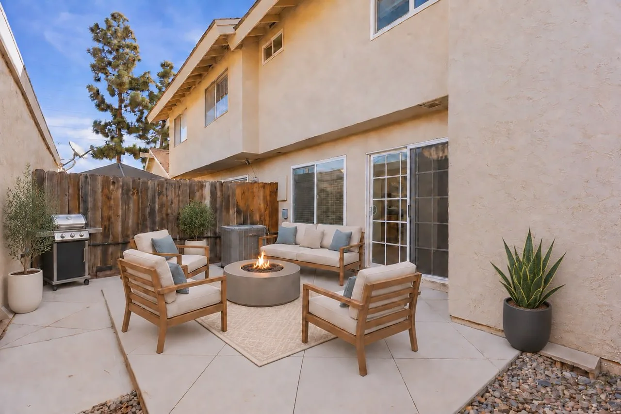 Virtually staged private patio at 8 Silverwood with outdoor seating, a firepit, and a table and chairs