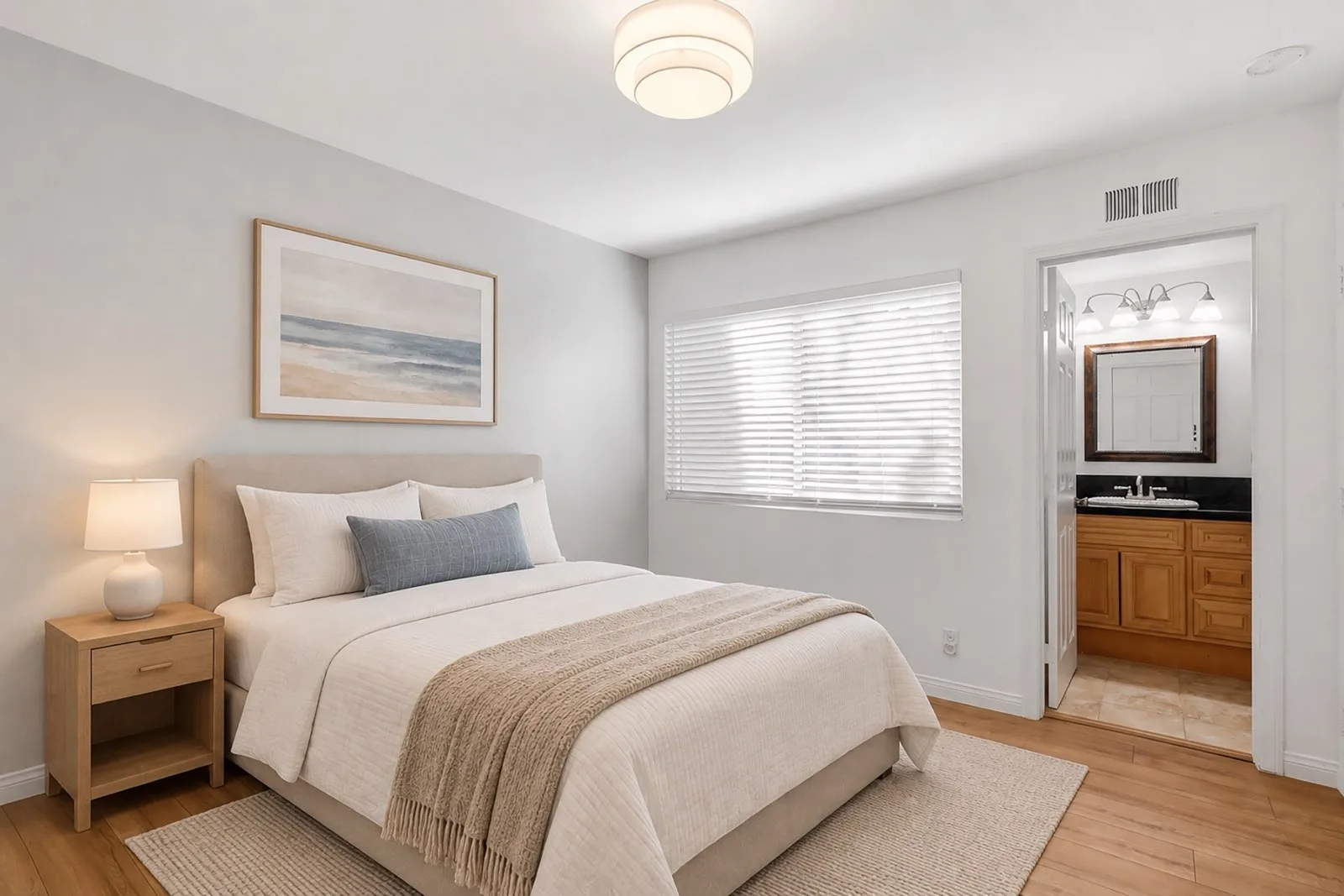 Virtually staged primary bedroom at 8 Silverwood with a bed, bedding, and a rug, the ensuite bath visible through the doorway