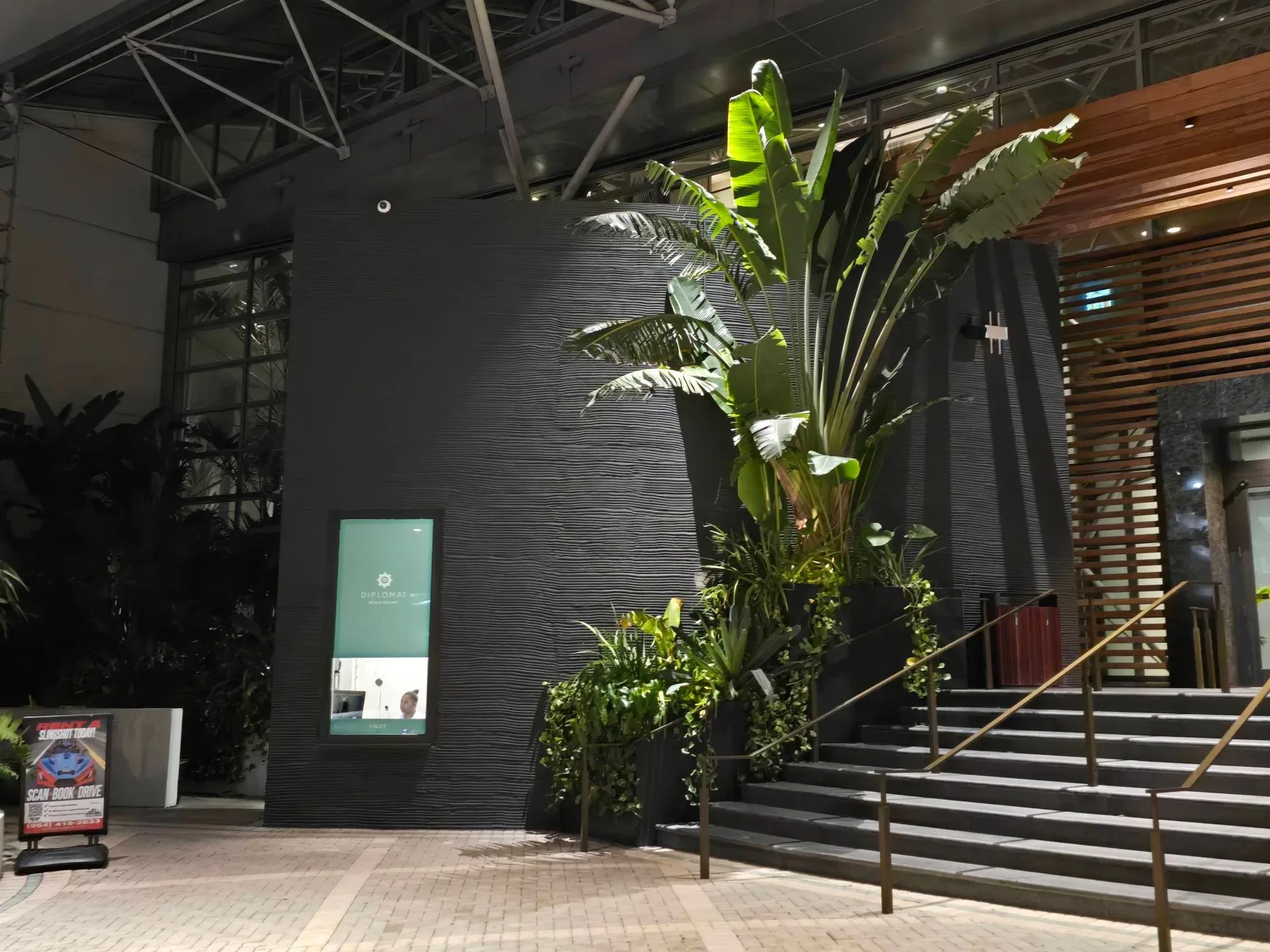 The modern lobby and check-in area at The Diplomat Beach Resort in Hollywood, Florida, with a lush plant wall and a scan-code sign for retreat registration