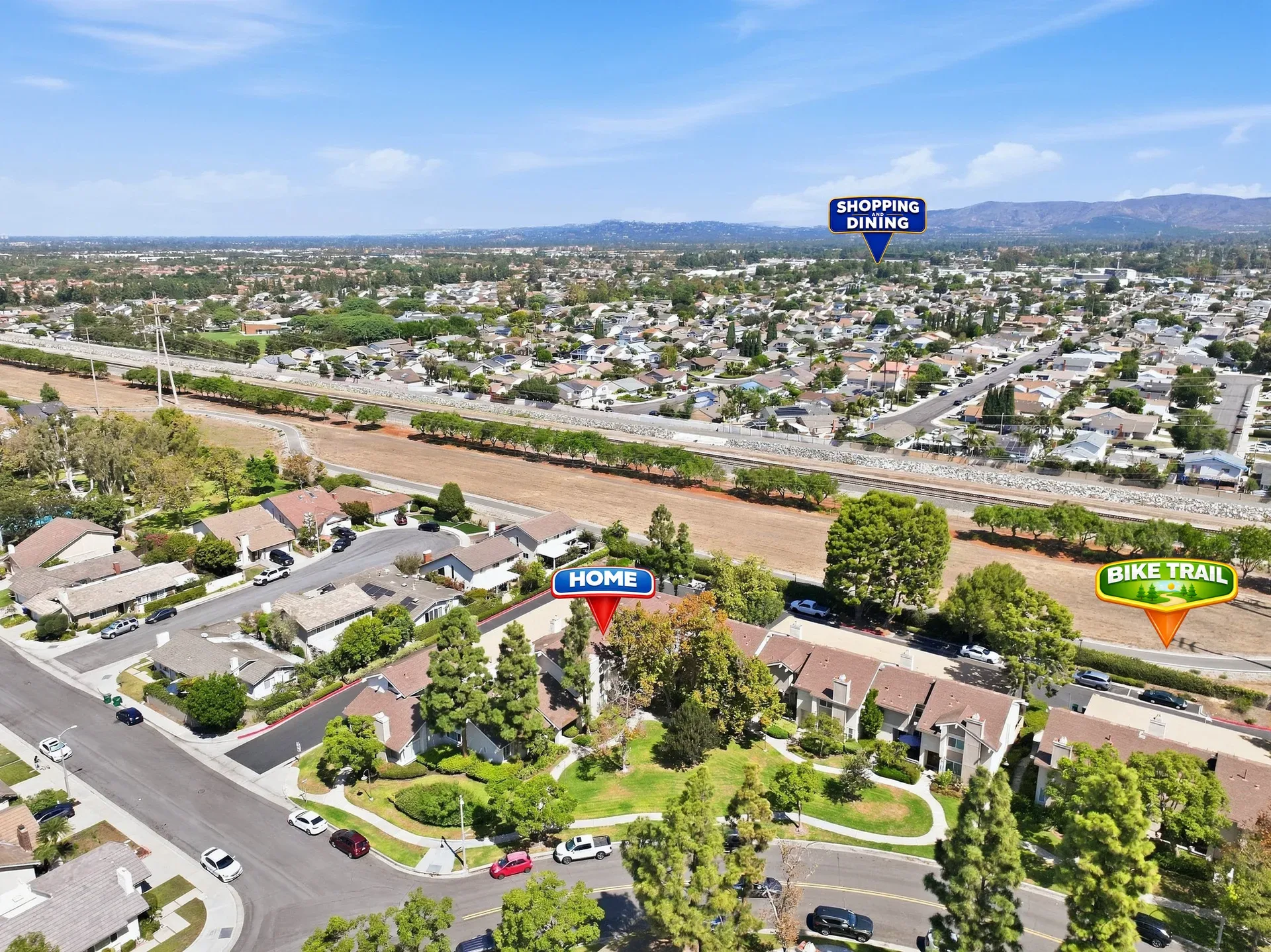 Aerial photograph of the Deerfield neighborhood around 8 Silverwood in Irvine, showing rooftops, tree-lined streets, and the established community that surrounds the home