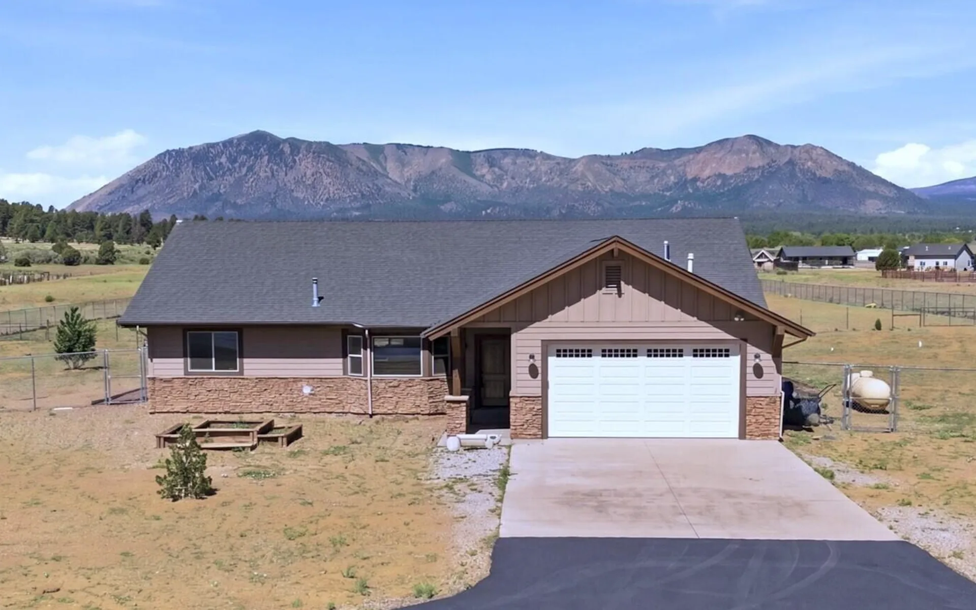 A single-story mountain home with lap siding set against open land