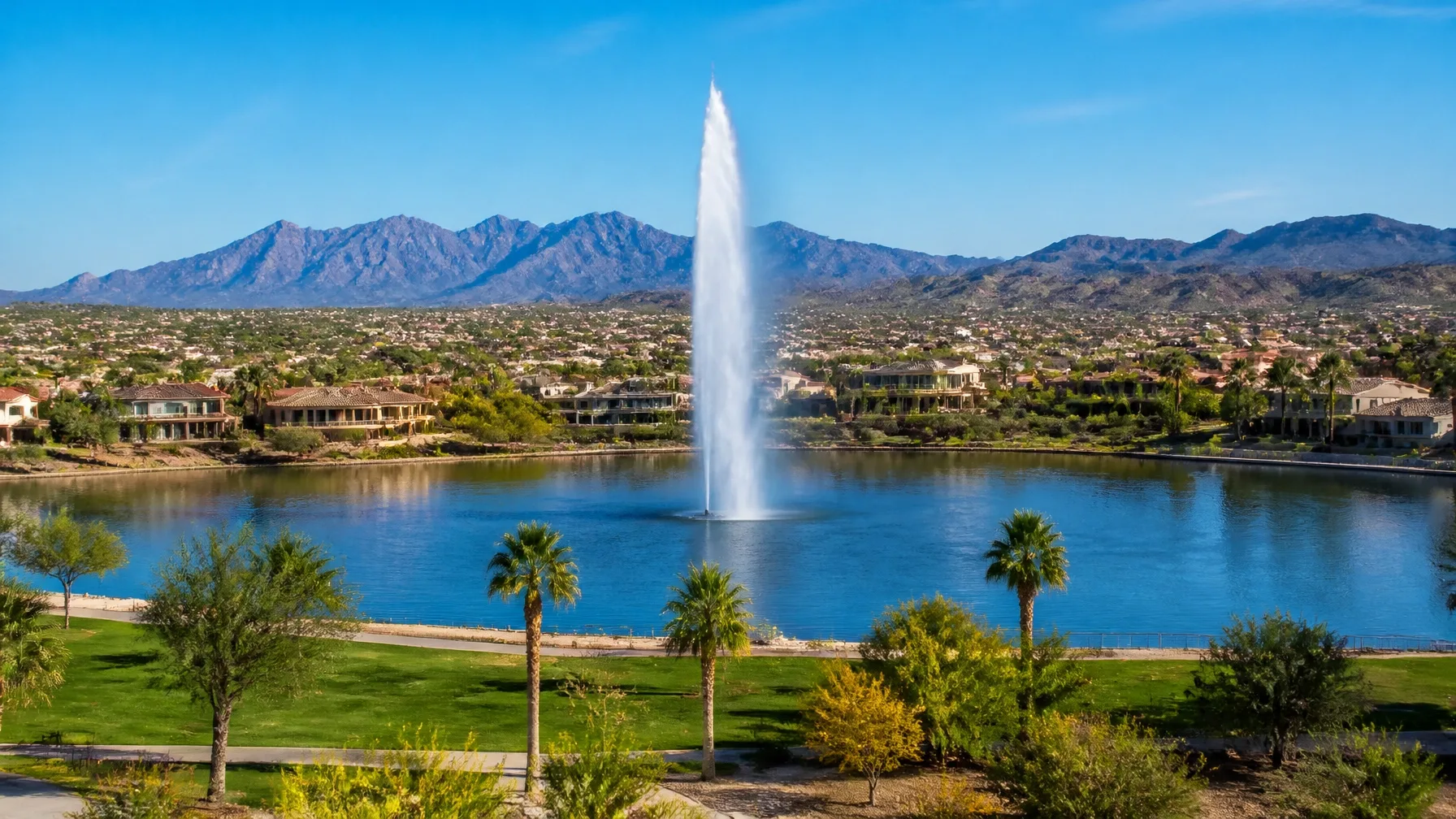 Community lake with a central fountain surrounded by desert-style homes