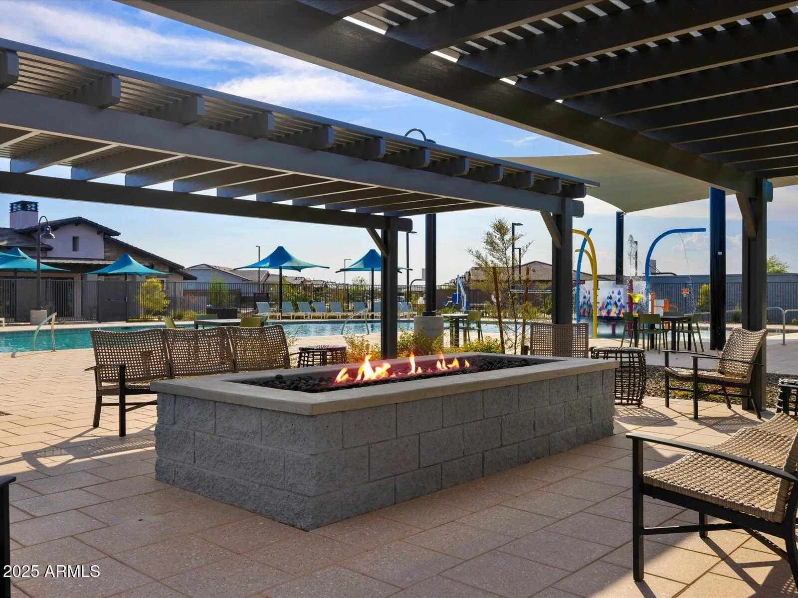 Community pool area with a fire pit and lounge chairs in a resort-style community