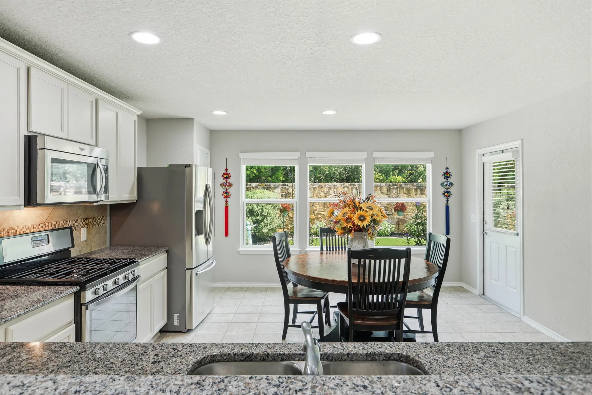 Kitchen with breakfast nook, granite countertops, and decorative tile backsplash